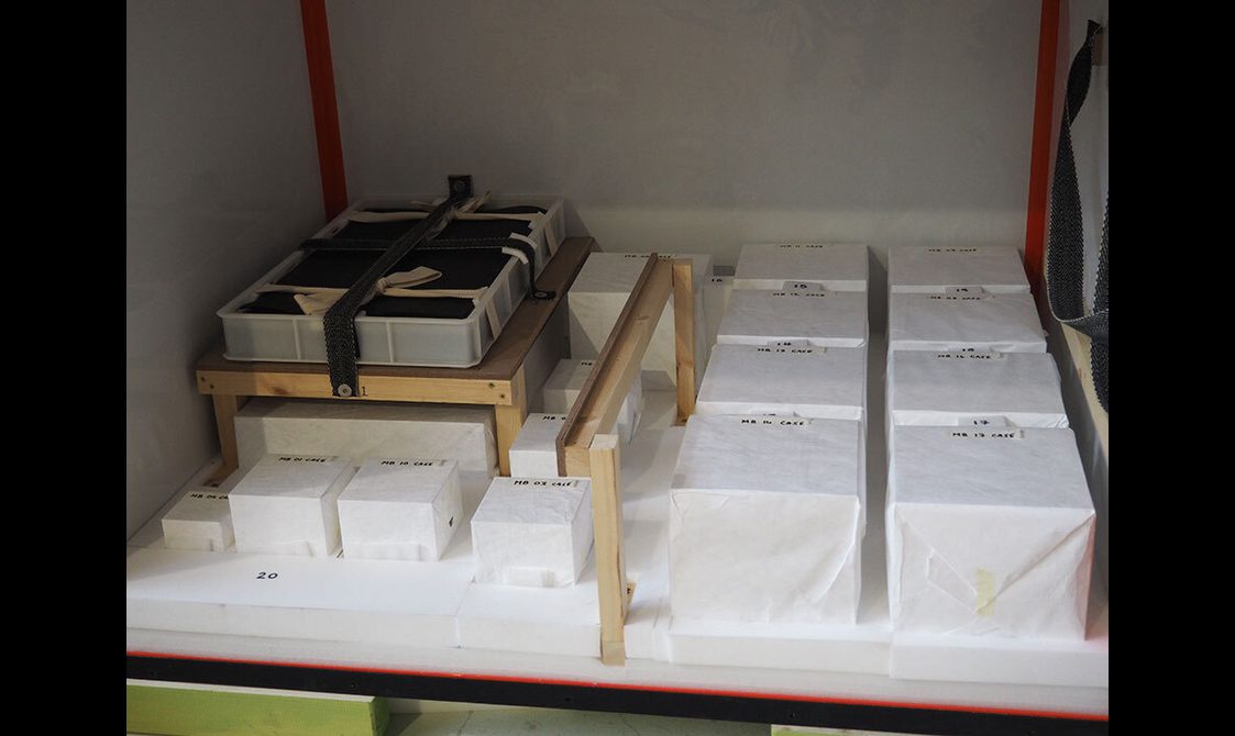 Multiple storage boxes securely packed into a crate for transport.